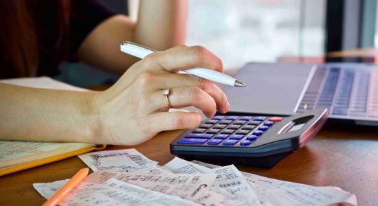 woman-holding-bill-using-calculator-and-calculate-2022-11-09-06-45-26-utc (1)